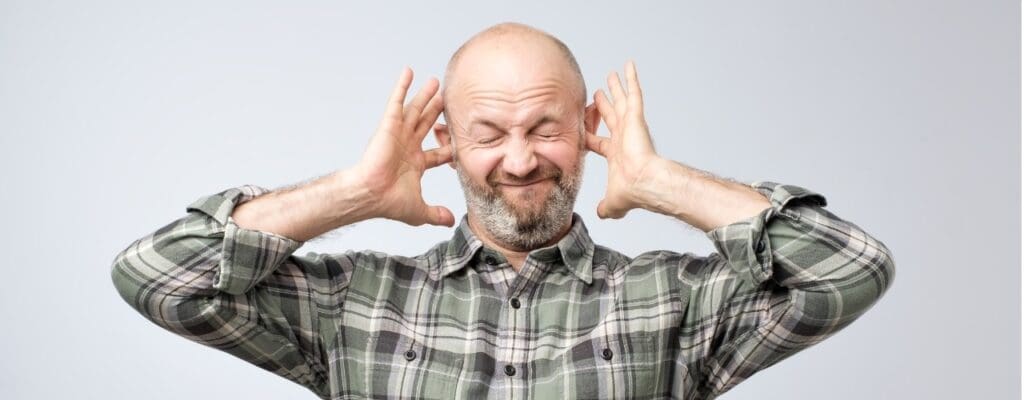 attachment-annoyed-mature-man-plugging-ears-with-fingers-picture-id1059142302