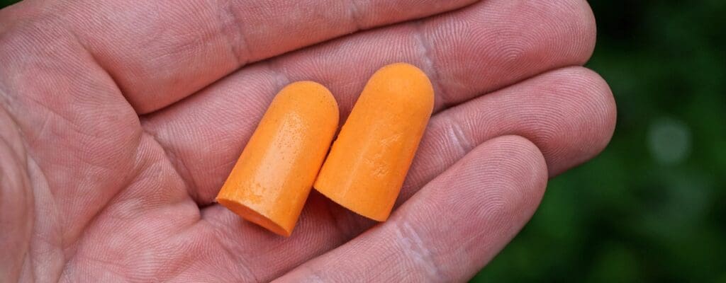 attachment-two-orange-plastic-earplugs-lie-on-a-palm-picture-id1252748009