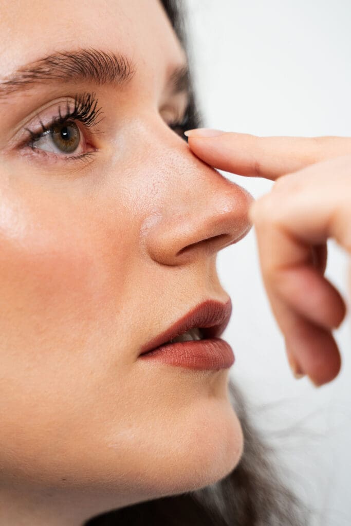 attractive-girl-touches-her-nose-before-septoplasty-rhinoplasty-to-reshape-the-nose-and-improve-breathing